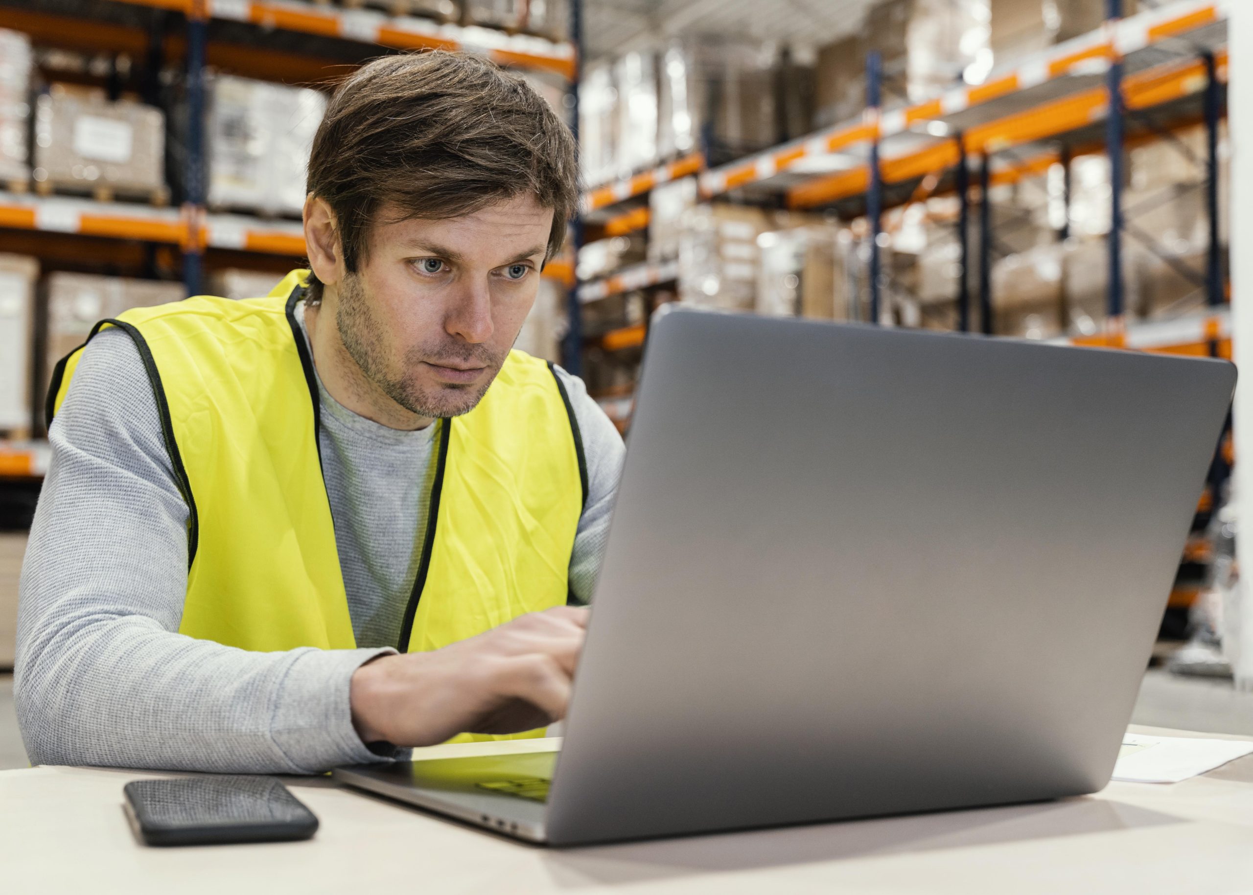 Profissional de logística trabalho no notebook dentro de um depósito